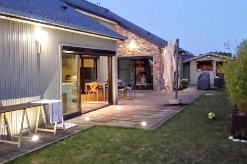 une terrasse avec des portes coulissantes en verre menant à une maison dans l'établissement Luxueuse villa, piscine intérieure, plage à 500m, à Saint-Coulomb