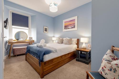 a bedroom with a bed and a mirror at Golf Course View Apartment - Craighead - Crail in Crail