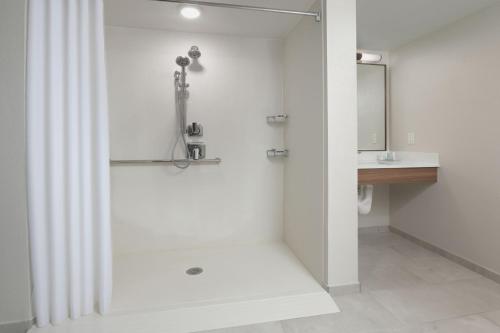 uma casa de banho branca com um chuveiro e um lavatório. em Fairfield Inn & Suites by Marriott Pottstown Limerick em Pottstown