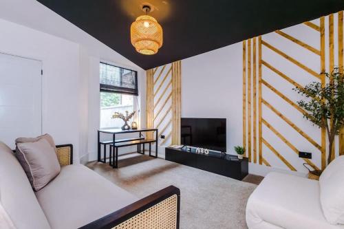 a living room with two white couches and a television at 4 Bedroom House Eccles in Manchester