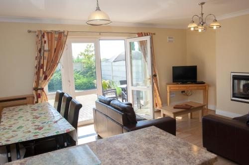 a living room with a table and chairs and a television at Knightsbrook Hotel Courtyard Accommodation in Trim