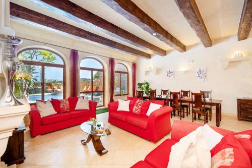 a living room with red couches and a dining room at Levecca 2 Holiday Home in Għasri