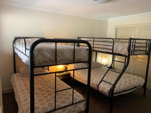 two bunk beds in a room with two lamps at Cowes Luxury Getaway in Cowes