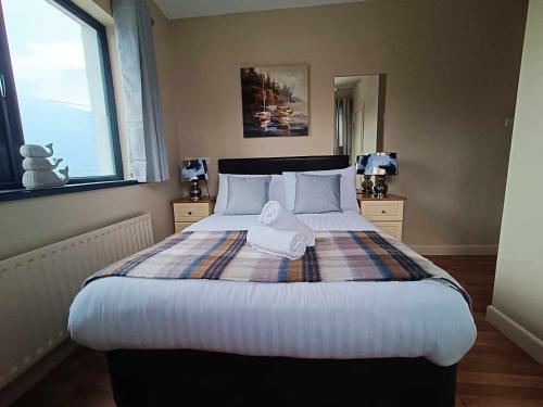 a bedroom with a large bed with two towels on it at Dingle Atlantic Lodge B&B in Dingle