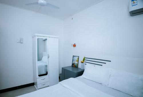 ダル・エス・サラームにあるBnV homesの白いベッドルーム(ベッド1台、鏡付)