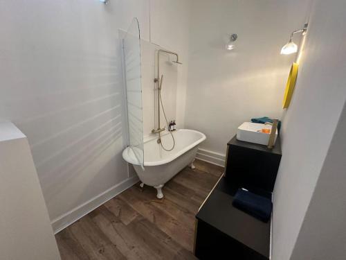a white bathroom with a tub and a glass shower at Appartement Standing dans hypercentre historique in Toulouse