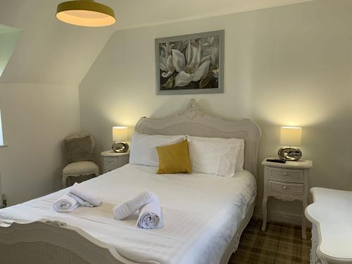 um quarto com uma cama branca e toalhas em Norman's Nook, The Bay Filey em Filey