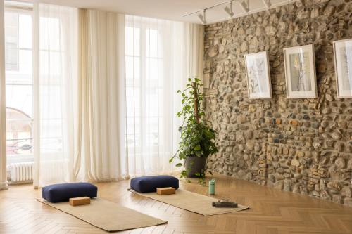 a room with two meditation mats in front of a stone wall at The Hamlet - Luxury Serviced Apartments in Geneva