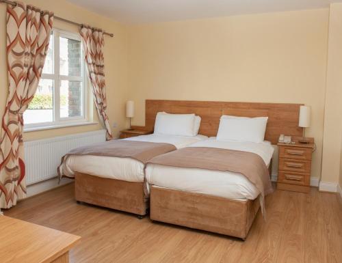 a bedroom with two beds and a window at Knightsbrook Hotel Courtyard Accommodation in Trim