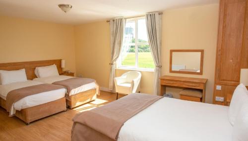 a hotel room with two beds and a window at Knightsbrook Hotel Courtyard Accommodation in Trim
