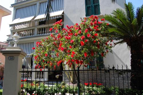 une clôture avec des fleurs rouges devant un bâtiment dans l'établissement Il sogno di Jo a 50 mt dal mare, à Borgio Verezzi