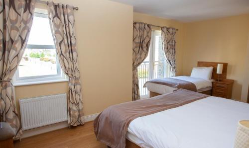a hotel room with two beds and a window at Knightsbrook Hotel Courtyard Accommodation in Trim
