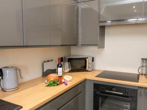 a kitchen with a counter with a bottle of wine at Apt 3 Hunter's Quay in Bridlington