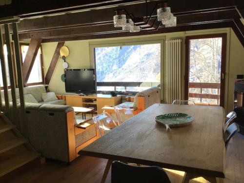 瓦爾圖爾嫩凱的住宿－Chalet charme vista panoramica sauna idromassaggio (Chalet Fanella)，客厅配有桌子和沙发