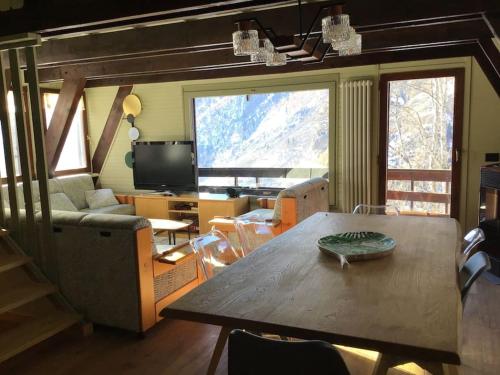 a living room with a table and a couch at Chalet charme vista panoramica sauna idromassaggio (Chalet Fanella) in Valtournenche