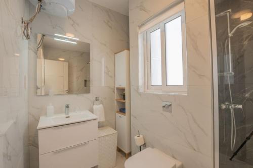 uma casa de banho com um WC, um lavatório e um chuveiro em BlissNest em Marsaskala