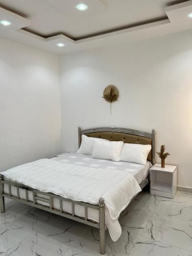 a bedroom with a bed with white sheets and pillows at Résidence Mounir in Thiès
