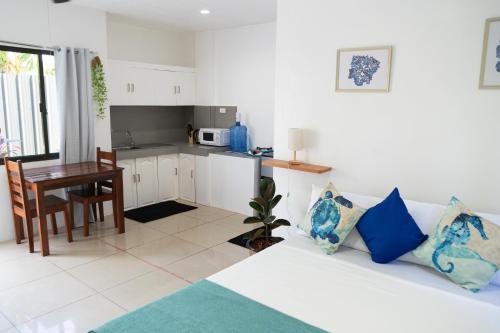 een woonkamer met een witte bank en een keuken bij Amara Pool & Villas 180Mbps Central location in General Luna