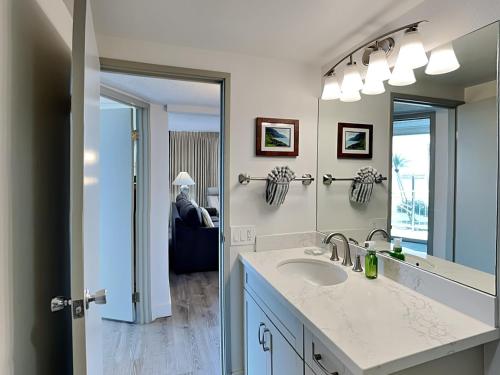 a bathroom with a sink and a large mirror at Island Surf 506 in Kihei