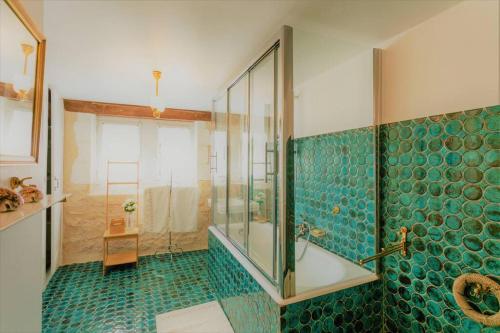 een badkamer met een bad en een douche met groene tegels bij Majestic Castle Retreat Near Lascaux Caves in Thonac
