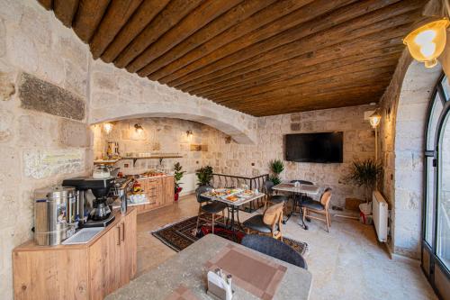 uma cozinha e sala de estar com uma parede de pedra em Ares Cave Suites em Goreme