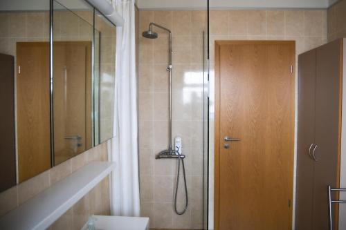 a bathroom with a shower with a phone in it at Setrið Guesthouse in Borgarnes