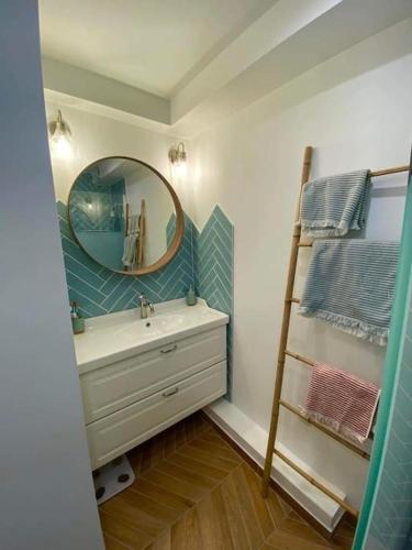La salle de bains est pourvue d'un lavabo, d'un miroir et d'une échelle. dans l'établissement T2 avec clim et terrasse vue mer, les Sablettes, à La Seyne-sur-Mer