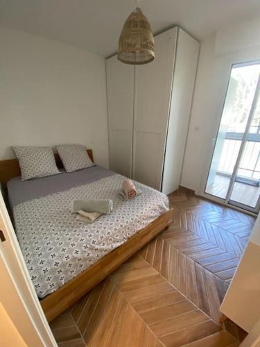 Ce lit se trouve dans un dortoir doté de parquet. dans l'établissement T2 avec clim et terrasse vue mer, les Sablettes, à La Seyne-sur-Mer