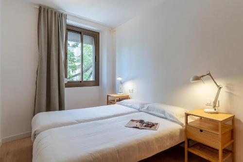 1 dormitorio con cama blanca y ventana en AB Cozy Flat in El Born en Barcelona