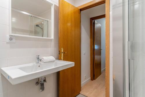 y baño con lavabo y espejo. en AB Cozy Flat in El Born en Barcelona