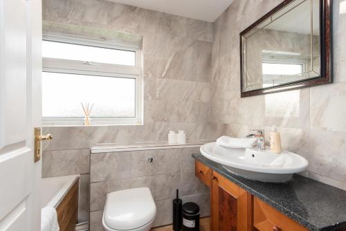 a bathroom with a sink and a toilet and a window at St Lawrence in Pittington