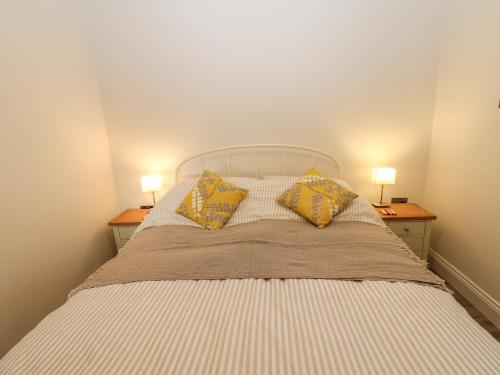 a bedroom with a bed with two lamps on two tables at The Barn in Bishop Auckland