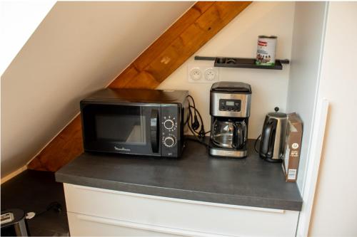 un micro-ondes posé sur un comptoir dans une cuisine dans l'établissement Ar Bili/Vue mer/Wifi, à Crozon