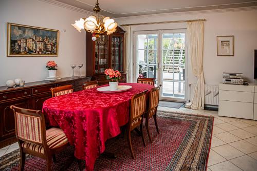 uma sala de jantar com uma mesa vermelha e cadeiras em Haus Helga em Idar-Oberstein