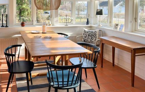 a dining room with a wooden table and chairs at Stunning Home In Beddingestrand in Beddinge Strand