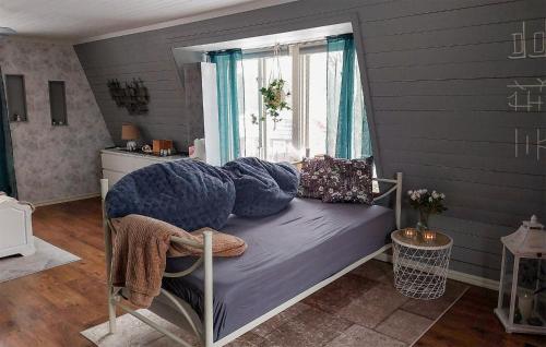 um quarto com uma cama com almofadas e uma janela em Lovely Home In Lrbro With Kitchen em Lärbro