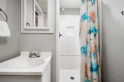 a bathroom with a sink and a shower curtain at Tranquil Cove in Port Aransas