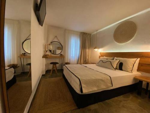 a hotel room with a bed and a desk at Papikinou Bay Suites in Adamantas