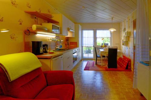 eine Küche mit einem roten Sofa und einem Esszimmer in der Unterkunft Ferienappartment Becker Zentrum in Lauterbach