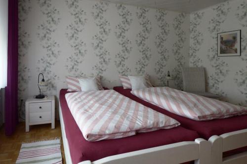 a bedroom with two beds with pink and white sheets at Ferienappartment Becker Zentrum in Lauterbach