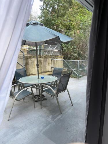 a table and chairs with an umbrella on a patio at Stylish entire 2bed apartment in London
