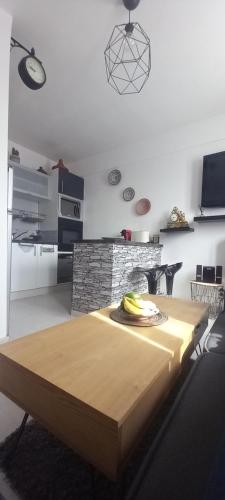eine Küche mit einem Tisch mit einem Teller Bananen drauf in der Unterkunft LE PHENIX Appartement calme et Cosy in Caen