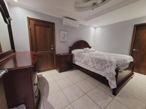 a bedroom with a bed and a dresser in it at Casa Bonita in Puerto Cortés