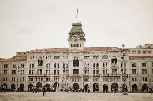 a large building with a clock tower on top of it at Monolocale Marina in centro storico in Trieste