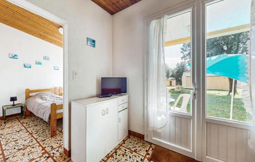 a bedroom with a tv on a cabinet and a window at Pet Friendly Home In Saint-Savinien in Saint-Savinien