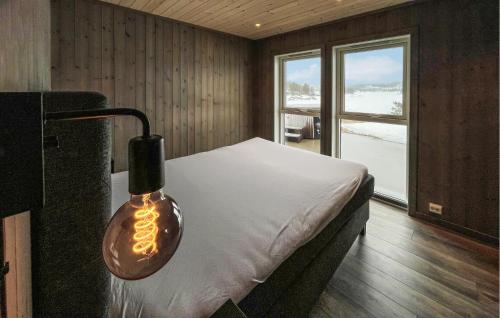 um quarto com uma cama com uma luz sobre ela em Gorgeous Home In Evje With Lake View em Evje