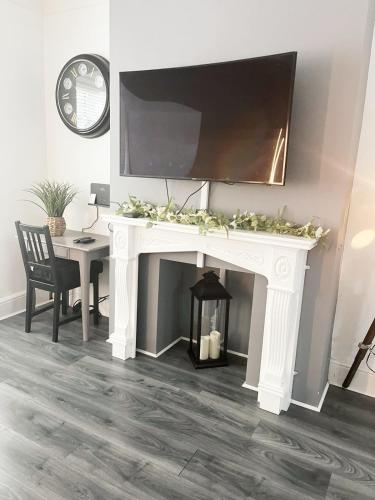 a white fireplace with a flat screen tv on top at Large 3 Bedroom Home, Sleeps 7, Ideal for Families & Contractors, Long-Stay Friendly, Hosted by Clark Property Estates in Southend-on-Sea