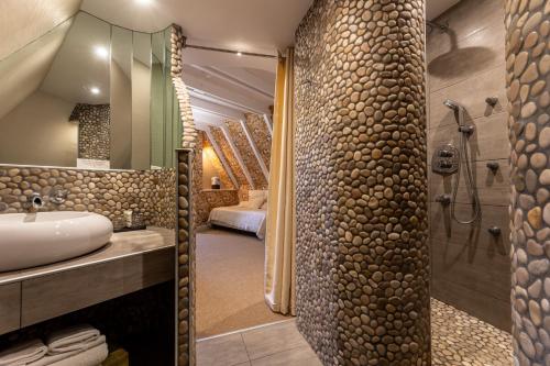 a bathroom with a sink and a shower at Le Bailliage Hôtel & Spa in Salers