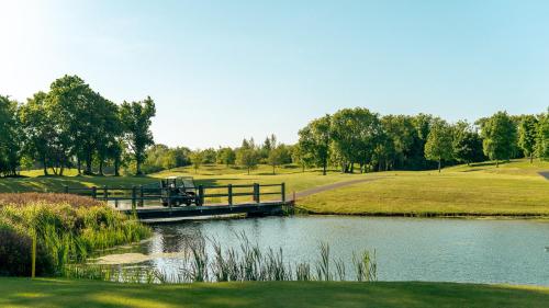 a bridge over a pond at a golf course at Knightsbrook Hotel Courtyard Accommodation in Trim
