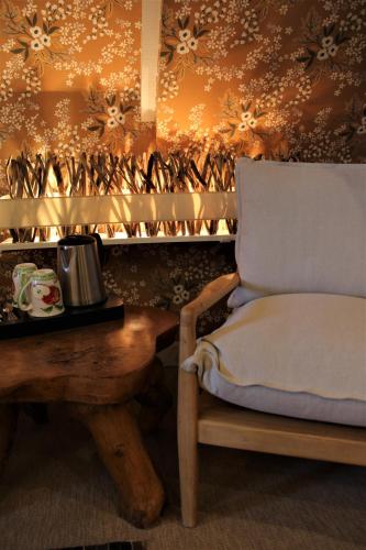 a room with a chair and a table with a coffeeucer at Le Bailliage Hôtel & Spa in Salers